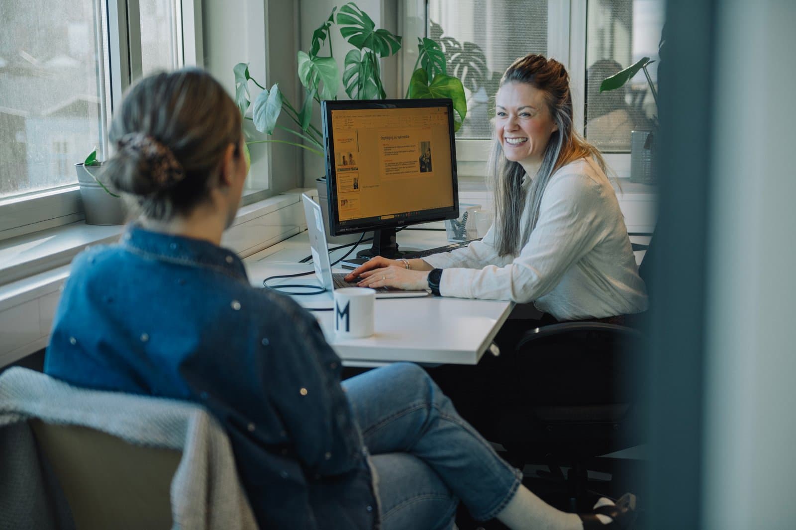 To kollegaer i samtale på en arbeidsplass